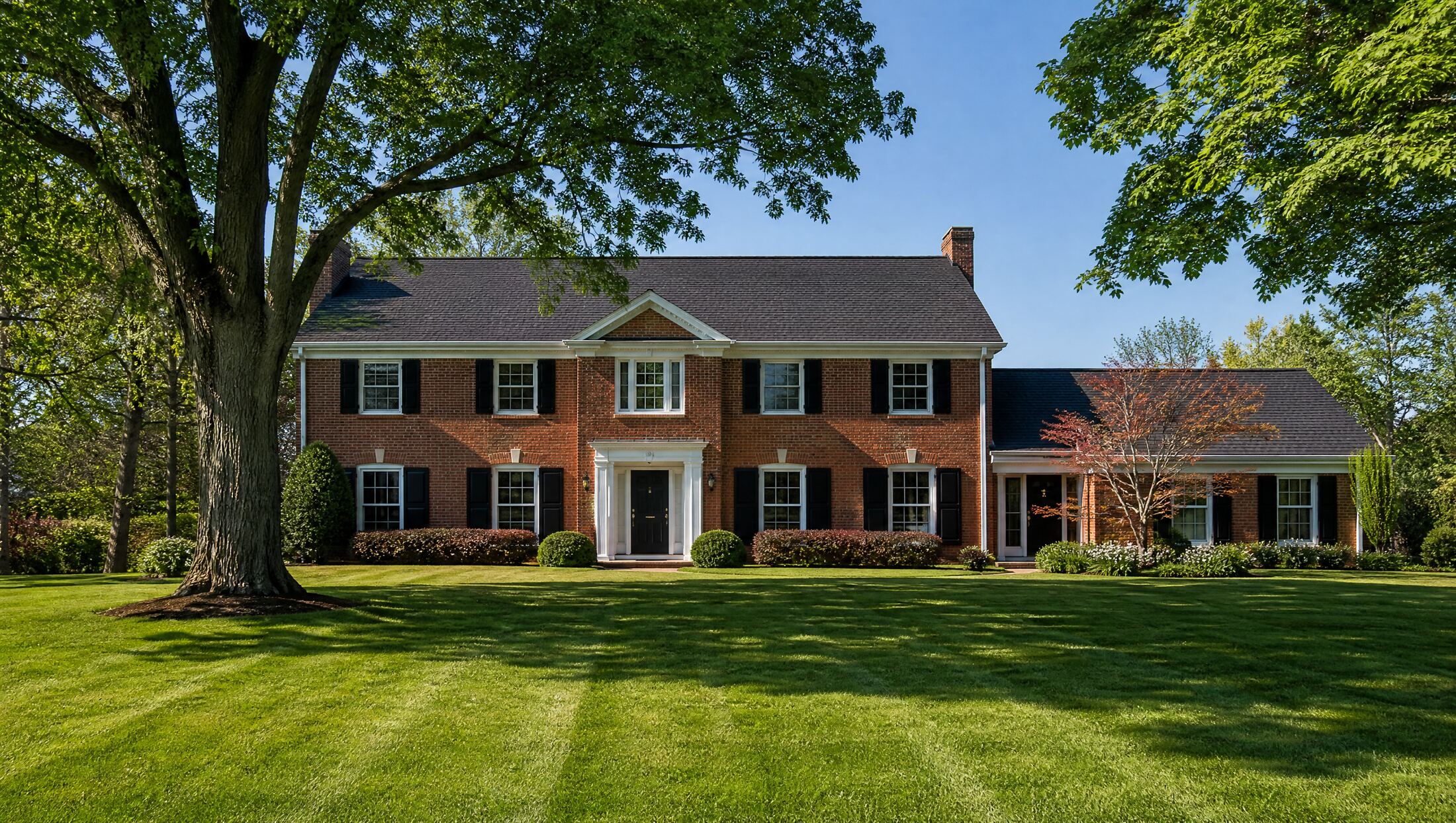 Illustration of a brick colonial home with white trim, typical of Troy, Michigan